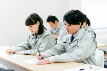 Obraz premium 工場・会社・オフィス・会議室で会議・セミナー・勉強会に参加するエンジニア・技術者・作業員の男女 