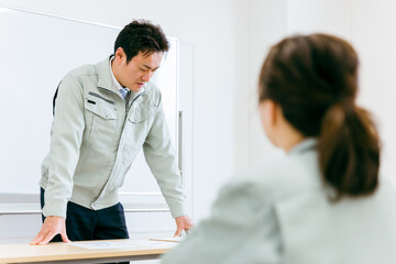 Obraz premium 工場・会社・オフィス・会議室で会議・セミナー・勉強会に参加するエンジニア・技術者・作業員の男性 