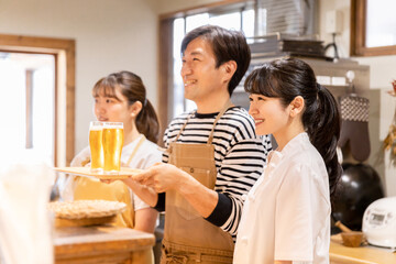 グラスの生ビールを持つ居酒屋・飲食店・カフェスタッフ