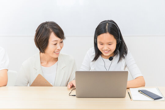 パソコンを使ってICT教育する先生と子供（女の子・日本人）