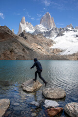 person jumping on rocks in front of Fitzroy mountains, laguna de los Tres