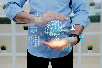 Businessman holding the brain and display virtual screen artificial intelligence (AI) to manage business processes through various icons, and artificial intelligence concepts.