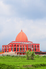 Fototapeta premium Moekhlas Sidik Mosque, Pandaan District, Pasuruan, East Java, Indonesia. in the morning with blue sky and white clouds. Because red colored, it also called Red Mosque