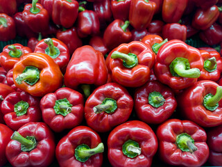 Red bell peppers stack up in grocery store.
