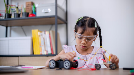 Asian students learn at home by coding robot cars and electronic board cables in STEM, STEAM, mathematics engineering science technology computer code in robotics for kids' concepts.