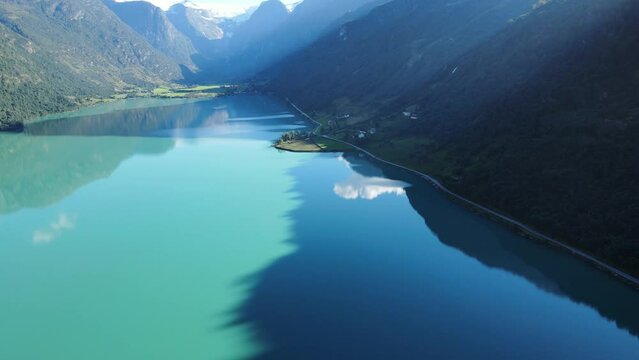 Oldevatnet glacier lake  in Norway with green water, reflection of clouds and mountains in it. Drone footage