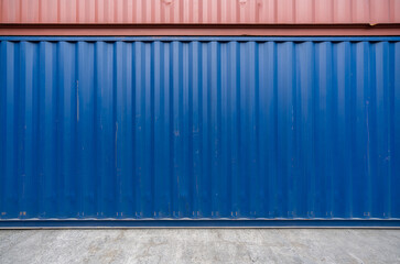 Blue and Red steel cargo containers stacked on concrete floor. Industrial background