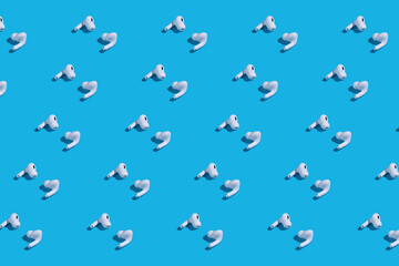 Rows of white earbuds on blue background