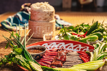 Traditional food in Thailand, Thai local food menu with raw food ingredient in the local name of Soi Ju, Sajin, Laab, koy, Soy Ju, raw meat with chili spicy sauce over dish on table background