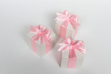 Three gift boxes with pink satin ribbon, isolated on white background.