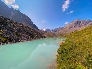 Mountain lake calm turquoise with clear water Karakabak in the Altai mountains with snow and glaciers.