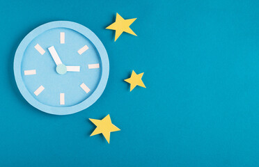 Sleep disorder, bedtime and insomnia concept. Paper model alarm clock with night stars on bright...