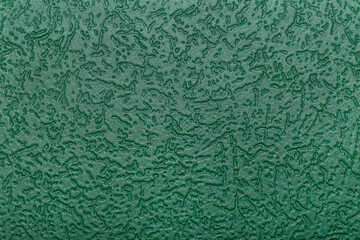Green background with patterns. Textured green wallpaper on the wall.