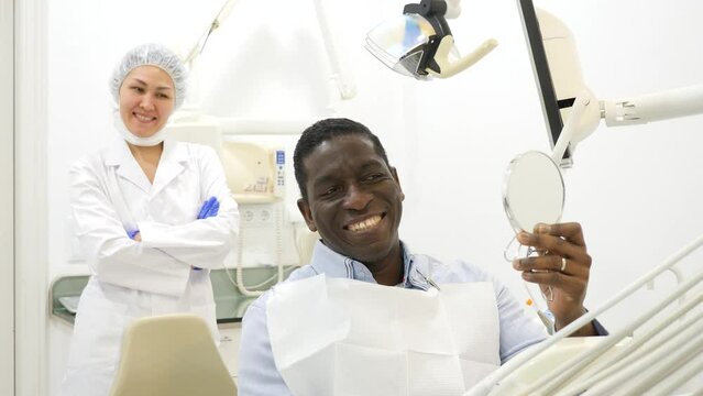 Smiling satisfied man in dental chair after surgery