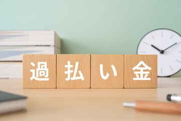 過払い金と書かれたブロックが置かれたデスク
