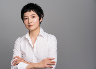 ビジネスで成功したアジア人女性ポートレート、白シャツを着て腕組みをしているミドル世代
