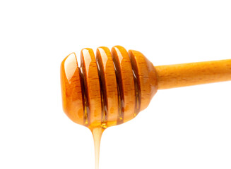 Honey flows down from a dipper close-up on isolation with space for text.