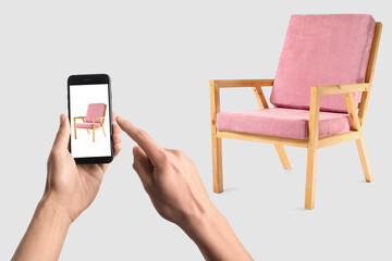 Man with mobile phone buying online new armchair in furniture store