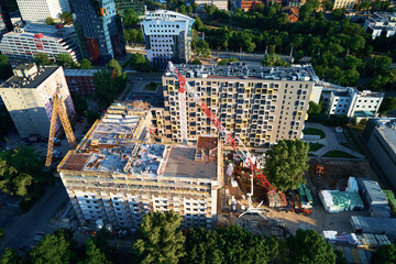 Aerial view of construction site with residential building under construction. Tower crane on...
