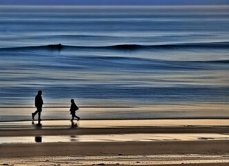 Fototapeta na wymiar Silhouette of father and son playing together on the beach enjoying time together
