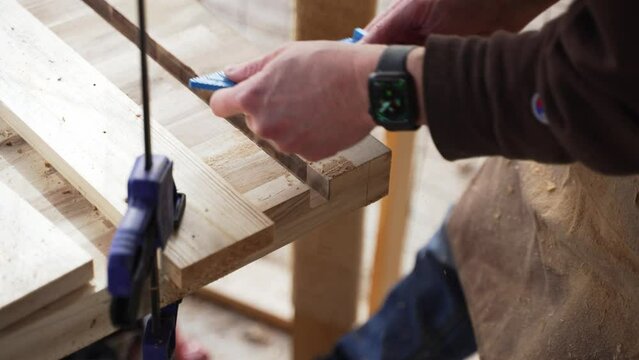 Woodworker Taking Measurements on Slabs of Wood. Wearing Apple Watch.