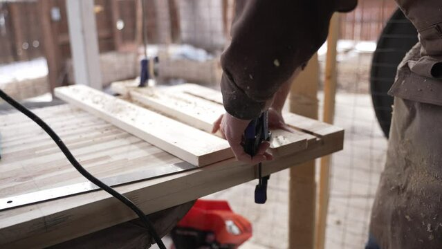 Woodworker Using a Nail Gun on Slabs of Wood.  60 FPS.