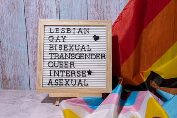 LGBTQIA description frame on Rainbow LGBTQIA flag made from silk material. LESBIAN, GAY, BISEXUAL,...