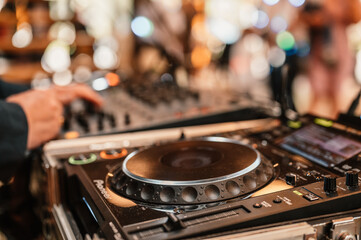 Fototapeta na wymiar DJ Spinning. mixing and scratching in a night club. DJ playing music at mixer. Closeup. Party. Dj playing music on rave party in nightclub. Disc jockey mix
