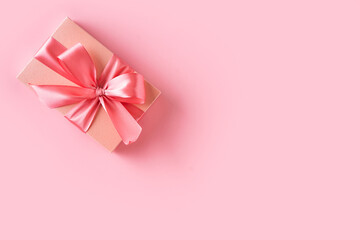 Pink gift box with bow on pink background