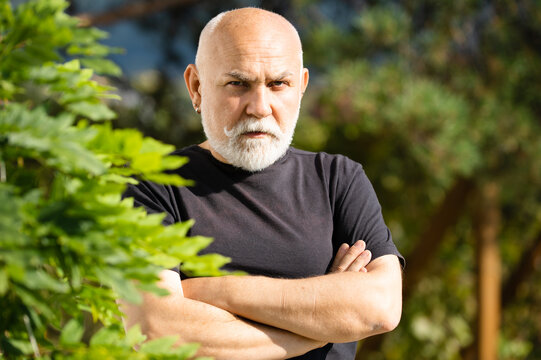 Grandfather. Portrait Of Serious Expression 60 Year Old Elder Senior Man Crossed Arms Outdoor. Mature Man With Serious Expression On Face.