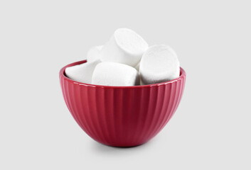 Fototapeta na wymiar Bowl with delicious marshmallows on grey background