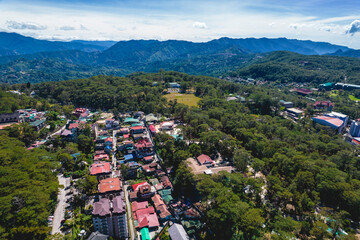 Baguio City, Philippines - Aerial of hotels and parks, with the untouched mountains of the Cordilleras in the distance.