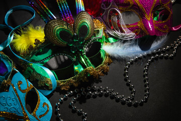 Carnival masks with beads for Mardi Gras celebration on dark background