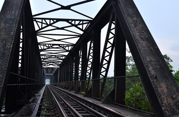 Vintage steel dark color rusty railway bridge on perspective shot
