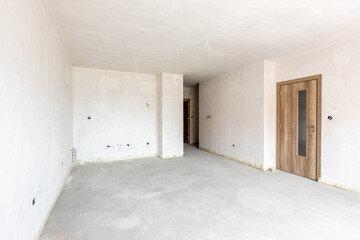 Obraz na płótnie Canvas New empty room under construction. Plaster walls. New home. Concrete walls. Interior renovation.