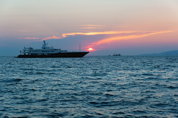 Fototapeta premium Sunset seascape with huge ship near Mykonos island, Greece