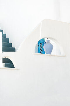 White building facade with blue steps and pot in Lefkes, Paros, Greece