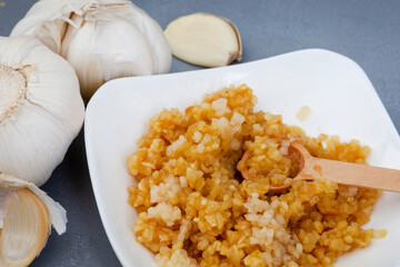 crushed and whole garlic on grey background, with selective focus close-up