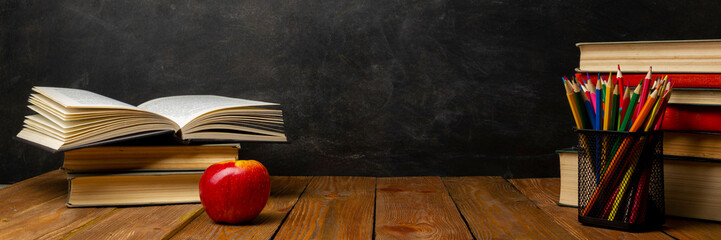 Back to school. Education background with books and apple over blackboard