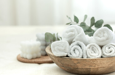 Spa composition with white towels in a wooden plate.