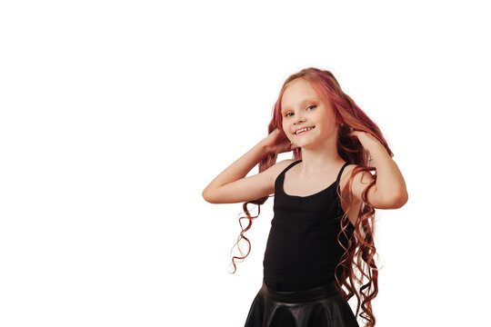 Studio shot of smiling happy little girl model with red long hair isolated empty white background, looking at camera. Stylish child girl posing shooting. Fashion style concept. Copy text space for ad