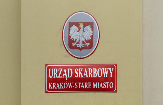 Tax office Urząd Skarbowy Kraków Stare Miasto and Polish eagle coat of arms plaque. Revenue office in Cracow Old Town district on January 29, 2023 in Krakow, Poland.