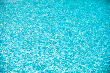 Ripple Water in swimming pool with sun reflection. Wavy water background.