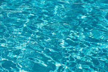Background of blue water in swimming pool with sun reflection, ripple water wave in pool. Clear water background.