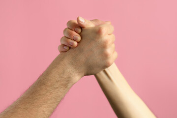 hands of man and woman in struggle for gender equality, female independence, male masculine power,...