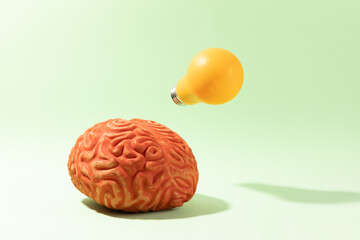 A brain having an idea on light green background