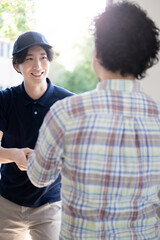 宅急便や配達物をお届けする配送業者の人　縦