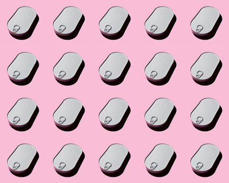 Pattern of rows of metal cans flat laid against pink background