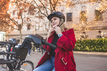 Mature woman wearing bicycle helmet at parking station