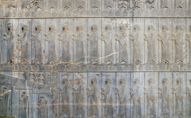 Ancient wall with bas-relief with assyrian warriors with spears, Persepolis, Iran